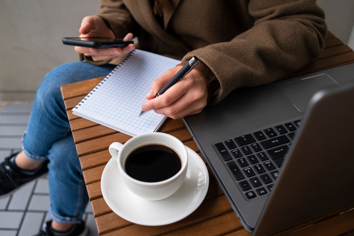 Woman Working in Street Cafe with Laptop